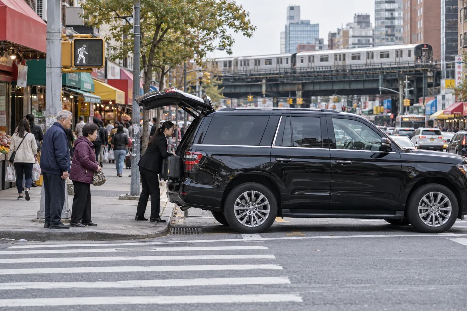 Black SUV pickup on a busy Flushing street beneath the elevated 7 train